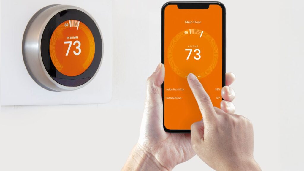 Hand turning on smart thermostast through the smartphone